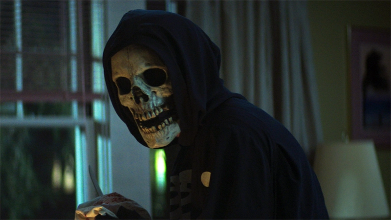 A masked skeleton guy in a black hoodie