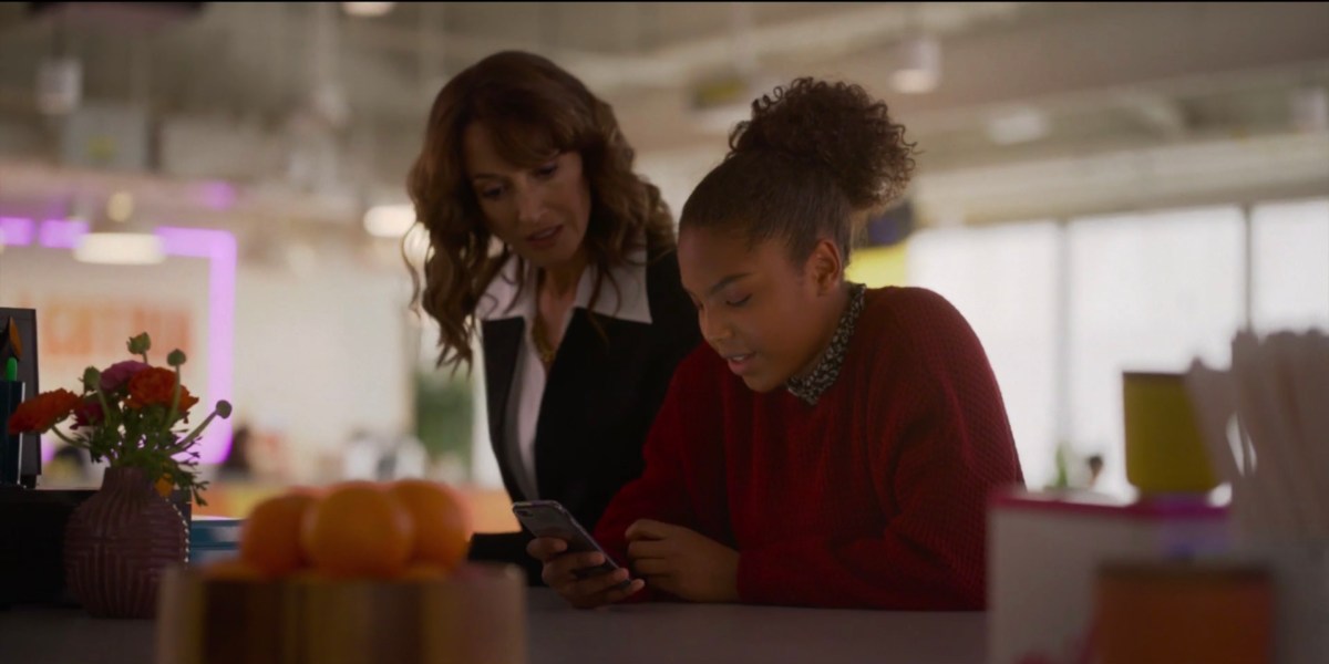 Bette leaning over Angie's phone