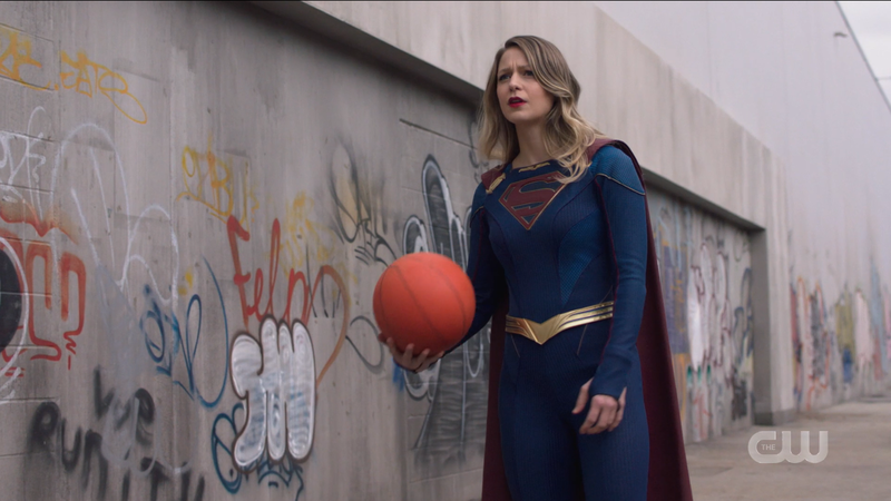 Supergirl holds a basketball like a regular Lakehawks player