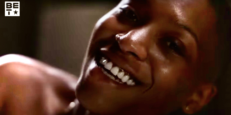 Jojo T. Gibbs smiles in a close up to the camera, you can see her bare shoulder.