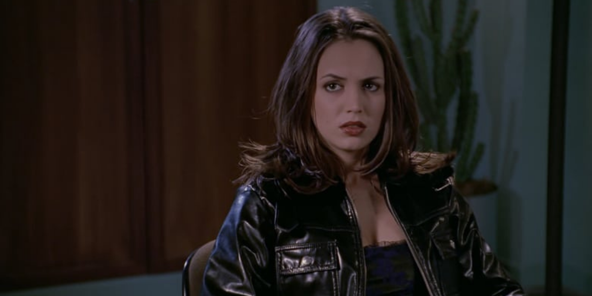 Image shows Faith sitting on a couch wearing a black leather jacket and giving an attitudinal face to the camera