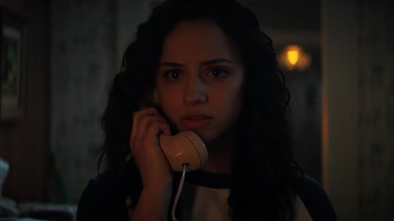 lesbian movies 2021 list still: Kiana Madeira stands in the dark on the phone