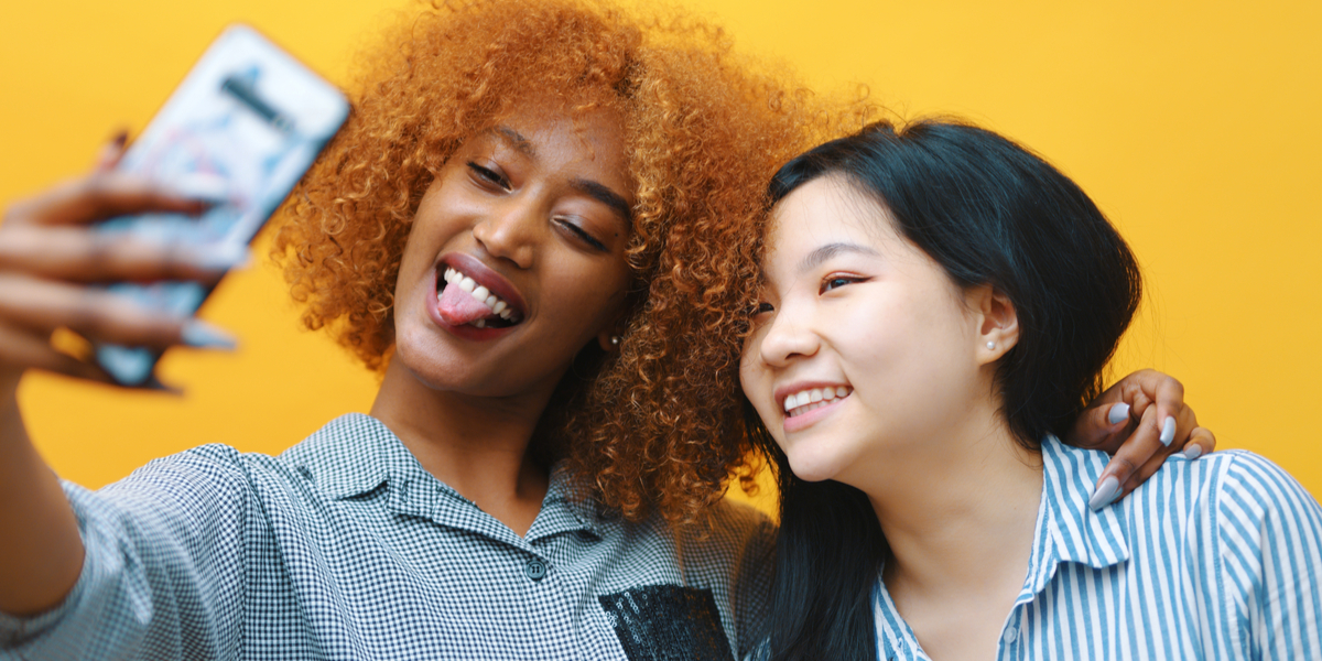 two young women make silly and cute poses for a selfie