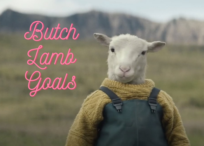 This is a screen shot from the movie, Lamb, where there is a little white lamb in a yellow knit sweater and gray coveralls. Over it, pink cursive text reads "Butch Lamb Goals"