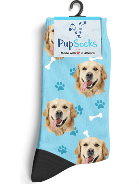 a light blue sock with various dog faces all over it