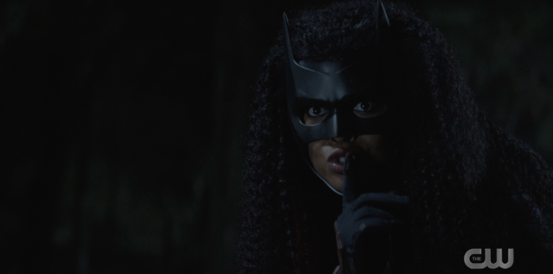 Ryan dressed as Batwoman doing the "shh" motion with her finger to her mouth