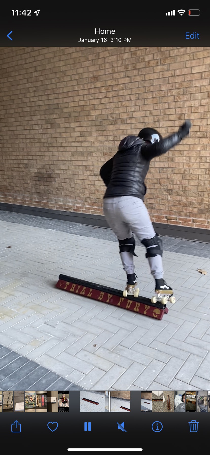 In this image, A human in roller skates, a helmet and knee pads skates along a slide rail which is like a rail Allison put on the ground to practice sliding on. 