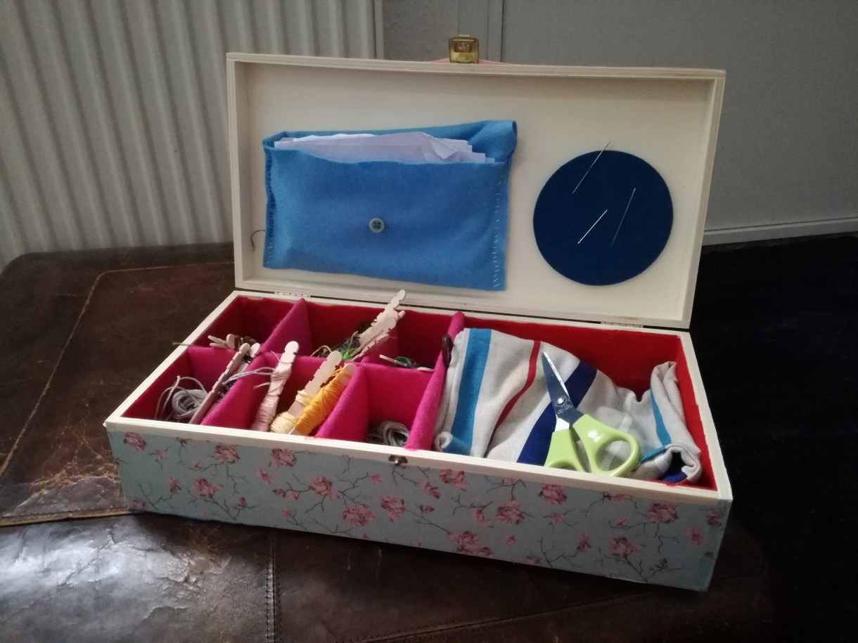 This is a photo of the box Kirsten's partner made for her. It contains embroidery thread, needels, fabric, scissors.