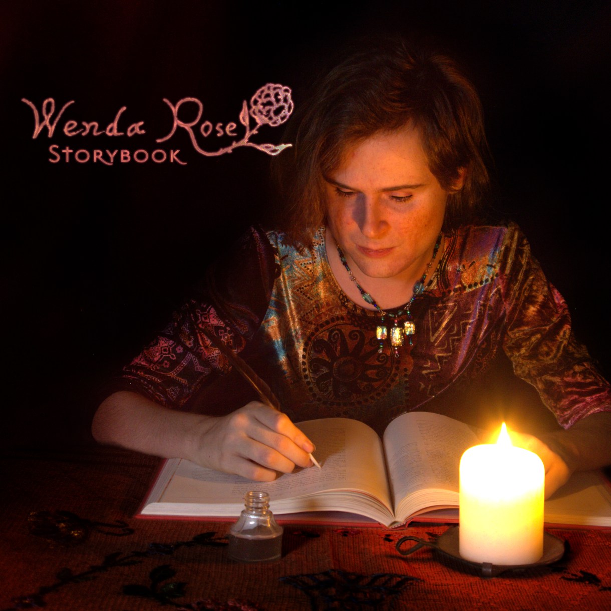 An album cover for the album Storybook by Wenda Rose. Here, Wenda sits at a table, writing in a book with a quill pen by candelight. There is a mystical vibe.