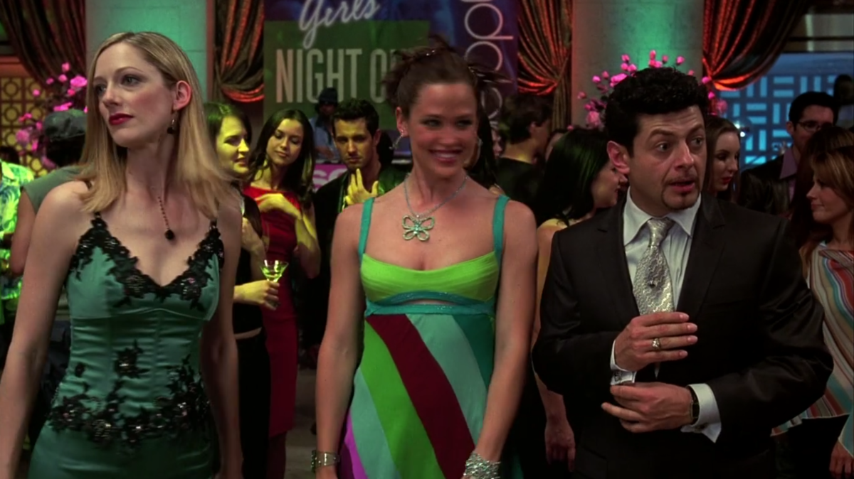 Lucy, Jenna, and Richard are dressed up for a party and standing on a dancefloor. The sign behind them says Girls Night Out