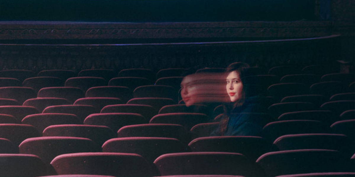 The singer Lucy Dacus sitting in an empty movie theater