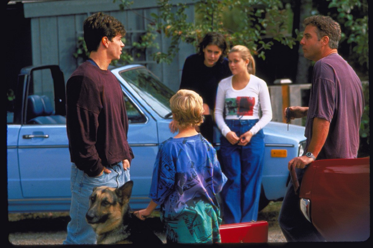 The whole family gathers in Fear around the car, the German Shepherd is visible