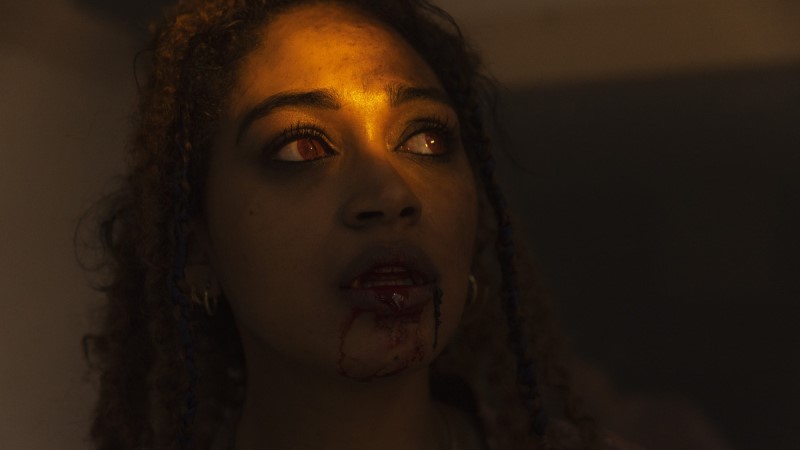 Lesbian vampire Olivia with red eyes and blood dripping from her mouth