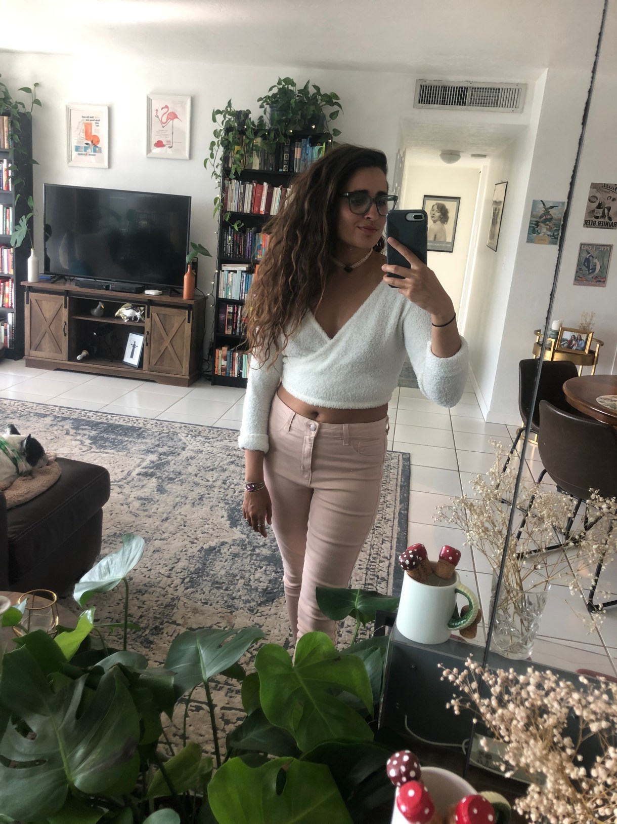 Kayla Kumari Upadhyaya wears a white fuzzy cropped wrap top, pale pink jeans, and a pink lace choker.