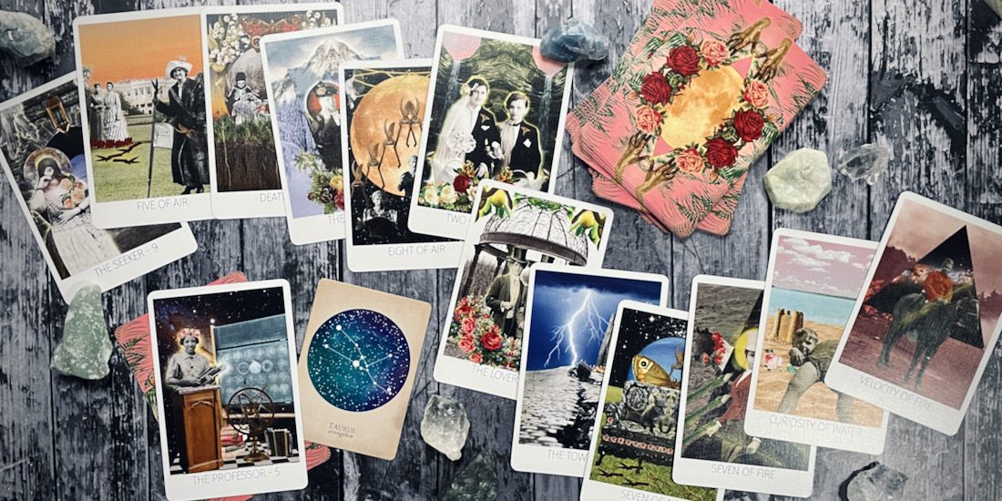 cards from the rosebud tarot and the compendium of constellations are displayed across a grey wood table