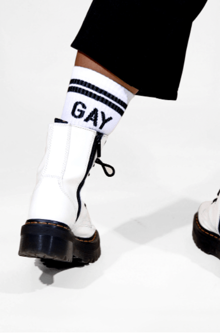 A closeup of the foot of a model wearing the Gay Chaos Socks