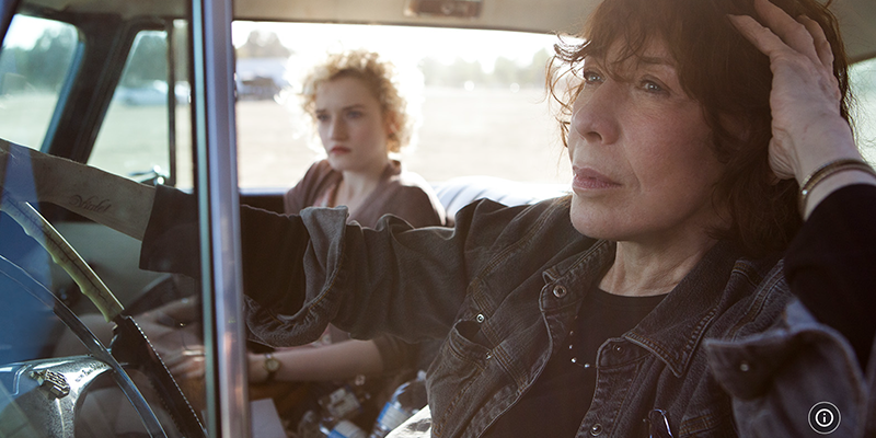 Elle and Sage ride together in a car with the windows down on a sunny afternoon