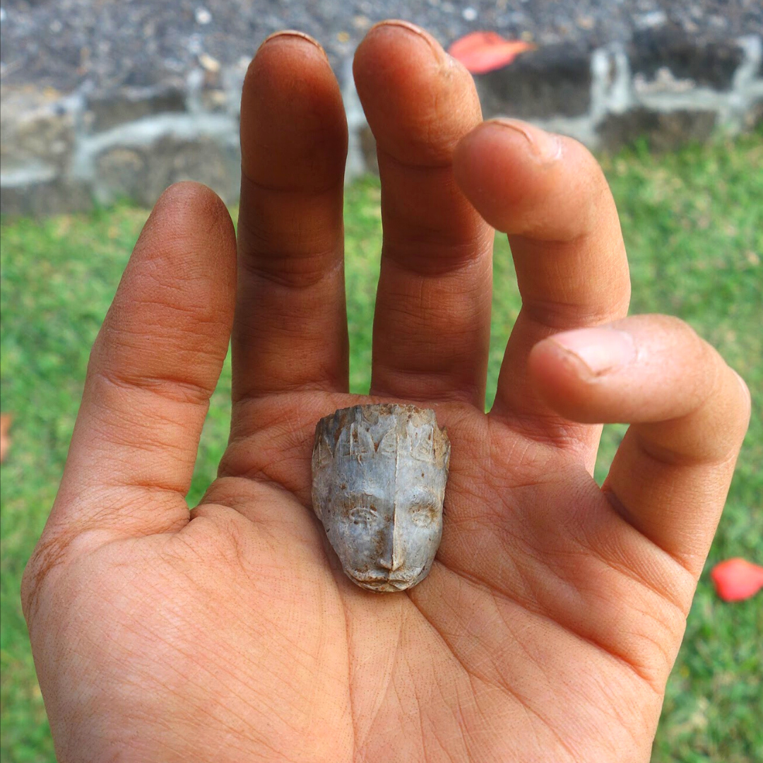 A close up of the palm of Viv’s hand. In the middle is a fragment with a bearded man’s face on it.