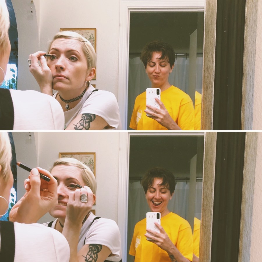 two photos of Laneia doing her eye makeup in the mirror while Amanda looks on and photographs from behind. amanda is wearing an oversized bright yellow tee. Laneia is wearing a baby doll tee with a bobby pin in her hair and one of those 90s chokers. In the second photo, they're both making silly faces.