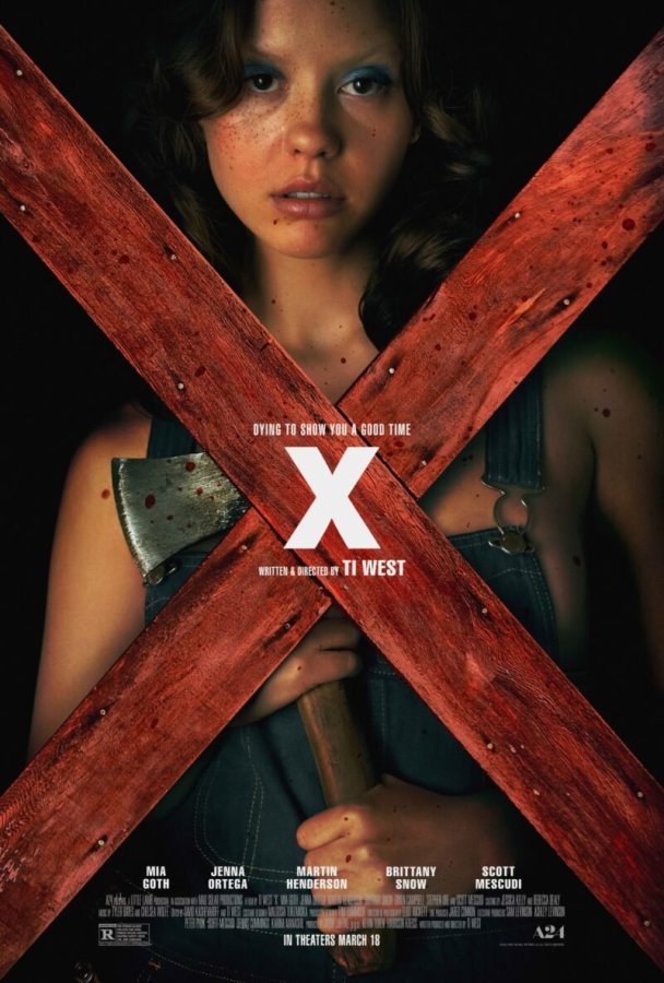 the cover of X shows a gamine-featured human holding an ax, gazing darkly through a crossed x made of red wood boards. this character is played by mia goth.