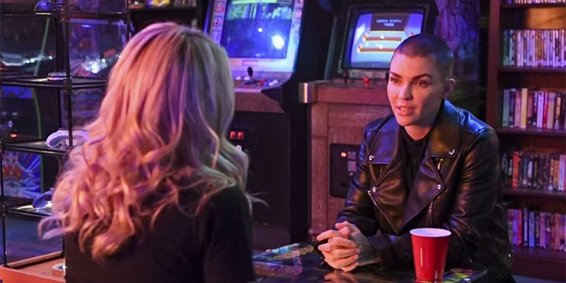 Ruby Rose in a leather jacket in their game room, talking to V