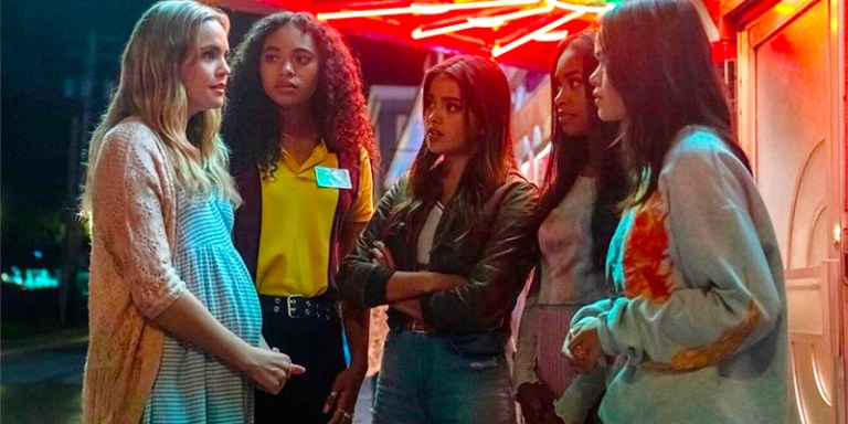 The new Little Liars huddle together in front of a neon light
