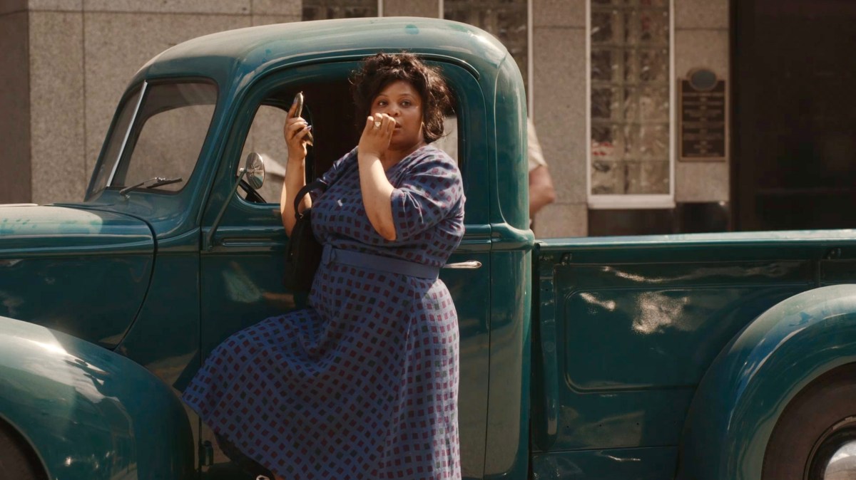 Clance checks her make up next to a pick up truck, her hair is dishelved