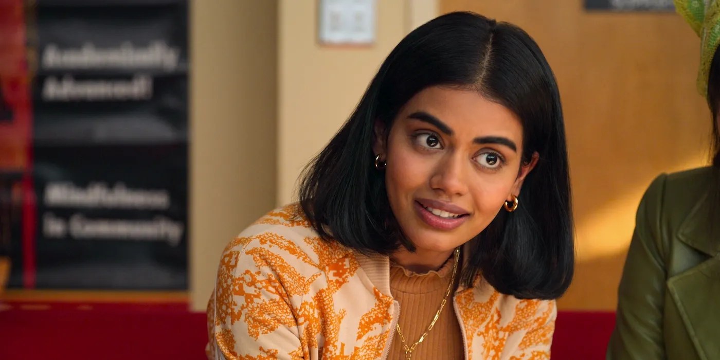 Never Have I Ever: Aneesa smiles at the camera, a South Asian teen girl with a bob that has a center part, wearing a yellow tie dye shirt