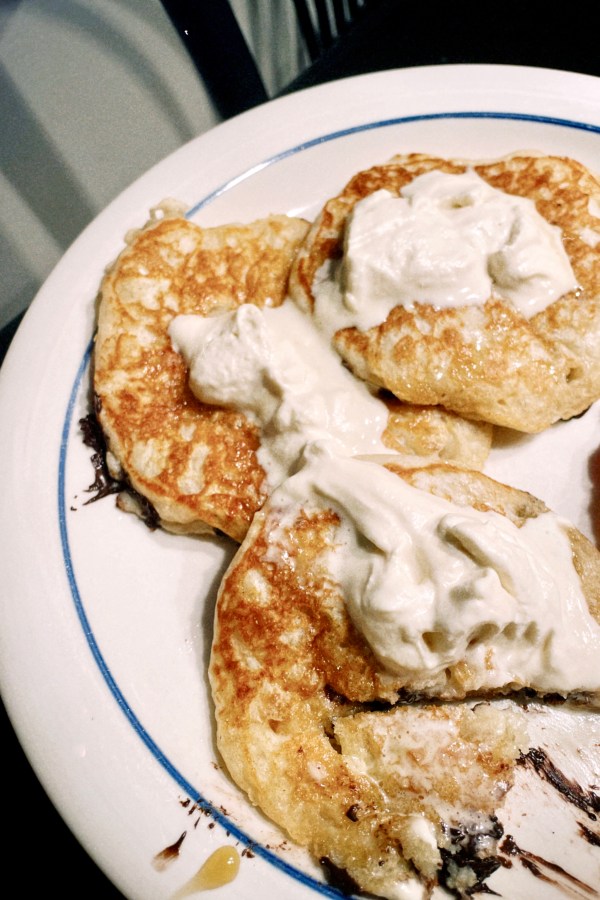 a photo of carmen's pancakes with chocolate chips and maple infused whipped cream