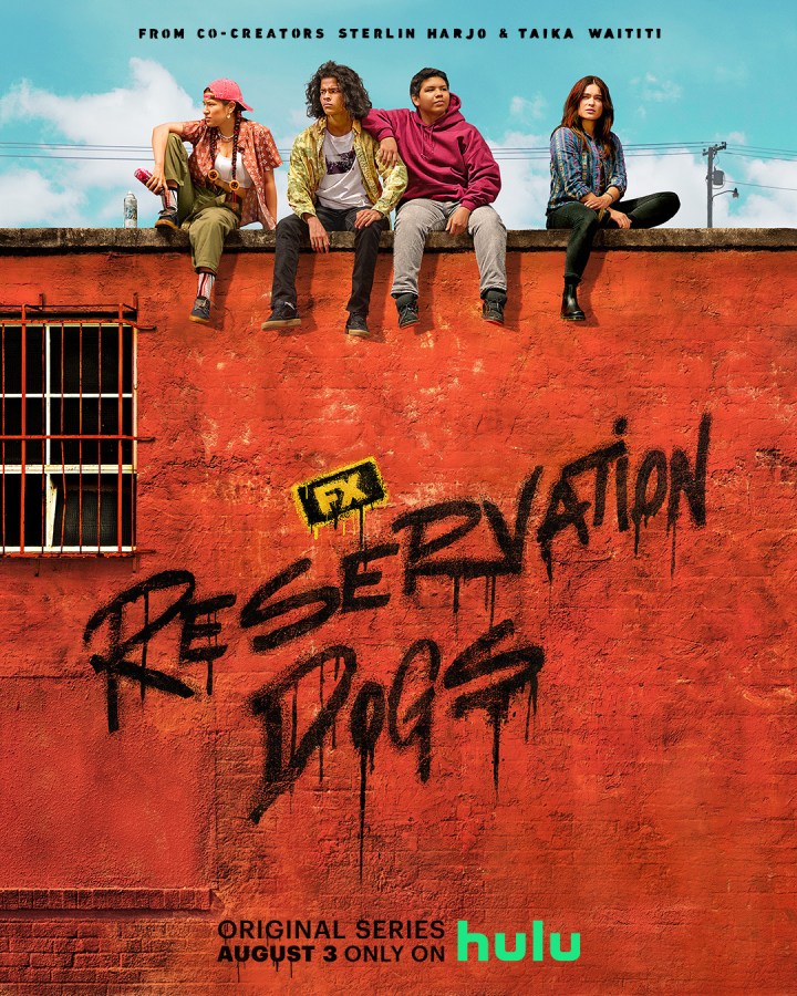 the cover of reservation dog shows four native america teens sitting on the roof of a building upon which the show's title is sprayed as though in graffitti writing
