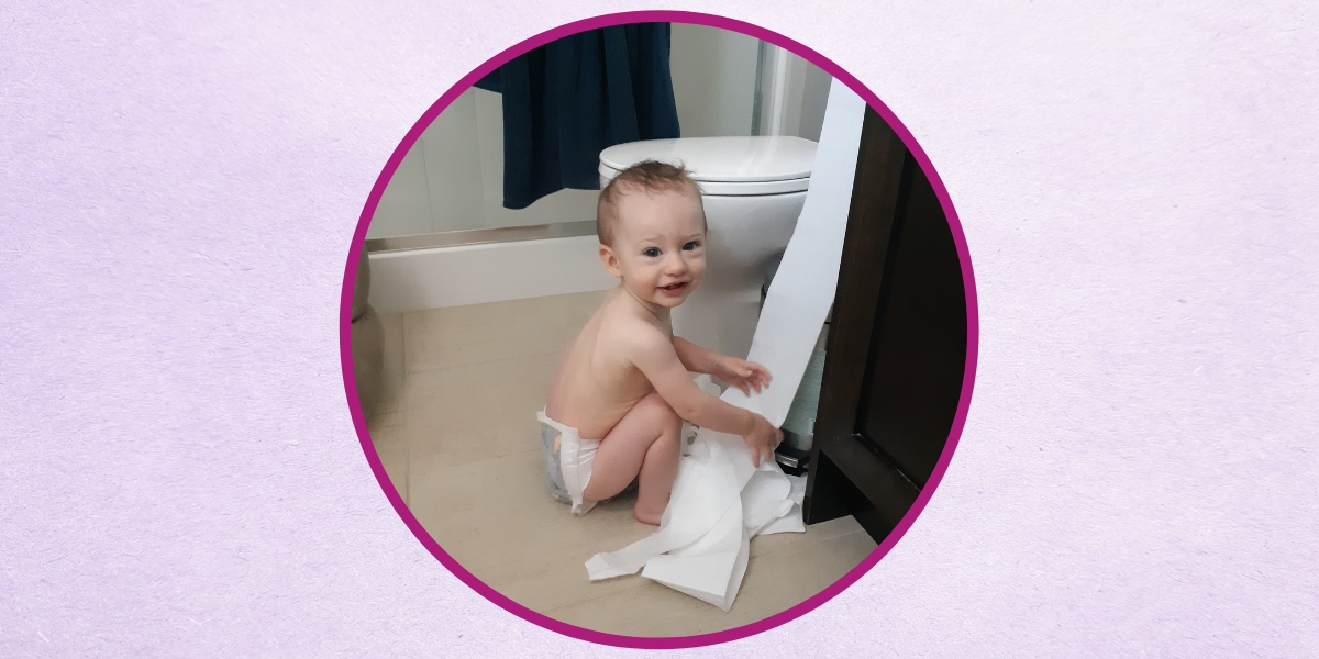 An adorable photo of Caseys' little one playing with toilet paper while mama does her skincare routine