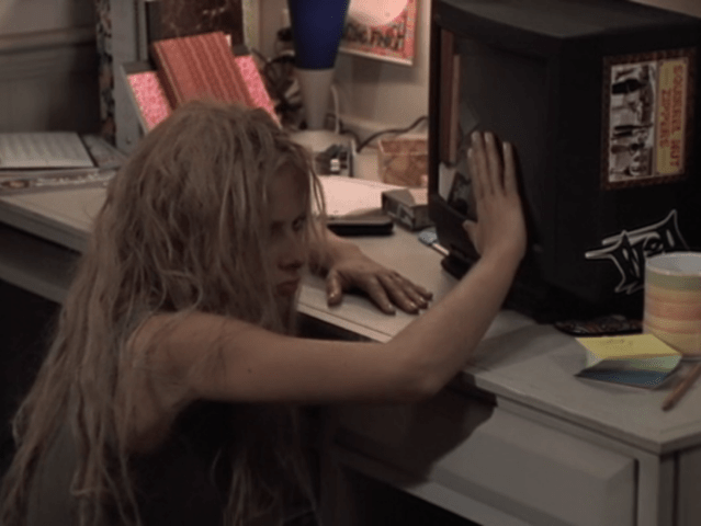 Buffy looking angry with matted hair, hitting her dorm room TV