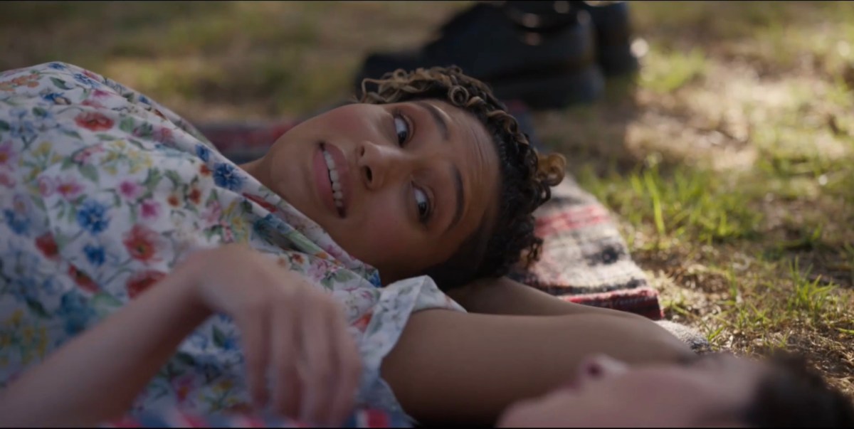 Sophie lying on the grass smiling at Finley