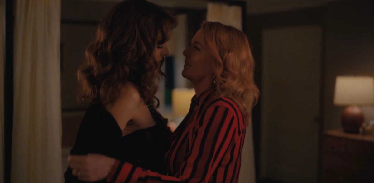 Tina taking Bette's shirt off