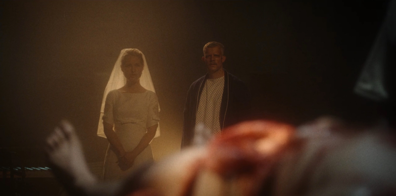 Russell Tovey as Patrick stands next to a woman in a bridal veil during a dream sequence.