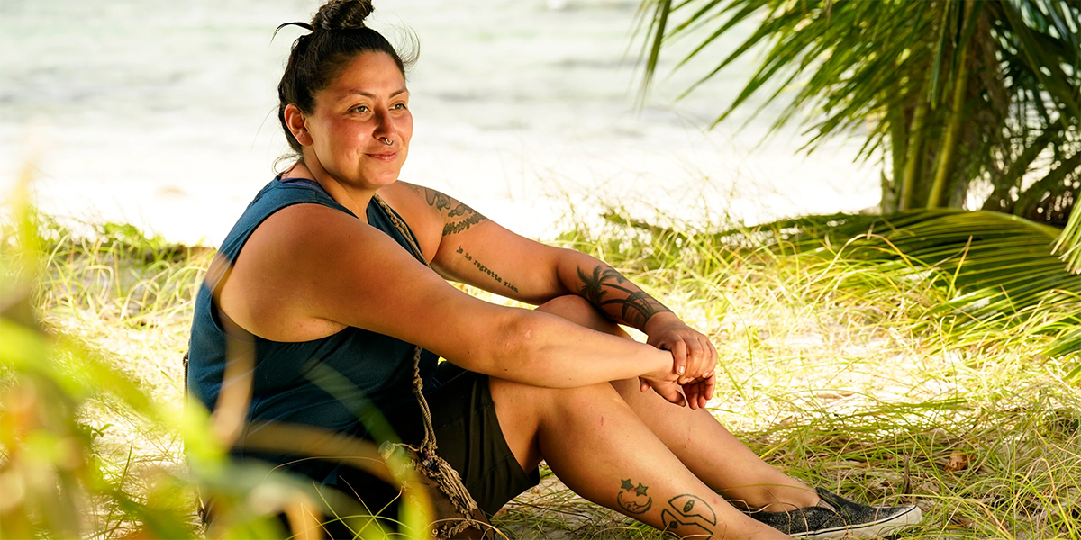 Karla sitting on the beach smiling