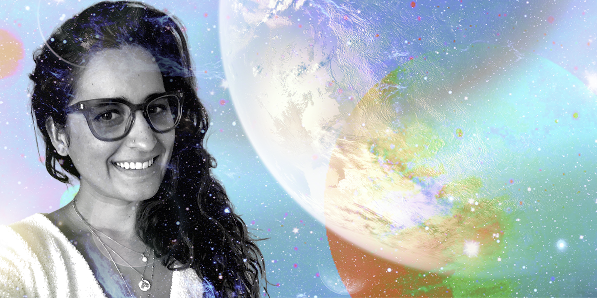 Kayla is set in black and white against a colorful spacey background. She is a South Asian woman with long brown hair and glasses who is smiling. She has a couple of soft pieces of jewelry on, too.