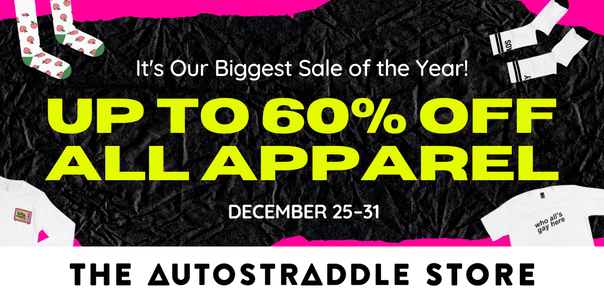 A store banner with a hot pink background and black paper. On top of it is the text "It's Our Biggest Sale of the Year! Up to 60% Off All Apparel! December 25-31" Also in each corner of the image are cutouts of store items, starting from top-left clockwise: the Peaches Socks, GAY CHAOS socks, who's All Gay Here White Tee, and Gay Chaos White Long Sleeve. At the bottom is The Autostraddle Store logo in black and white.