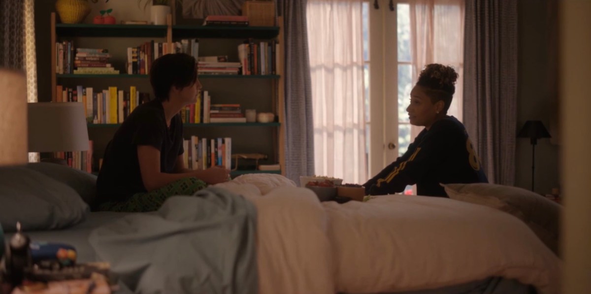 Sophie and Finley sitting on the bed facing each other