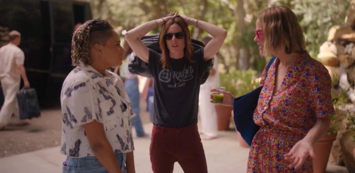 Sophie, Shane and Alice standing talking after getting off the retreat bus. Shane has her arms over her head holding a bag, Alice and Sophie are debating