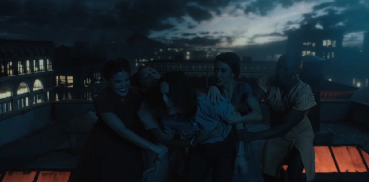 Girls holding onto Shane as she struggles to get away from them on the roof