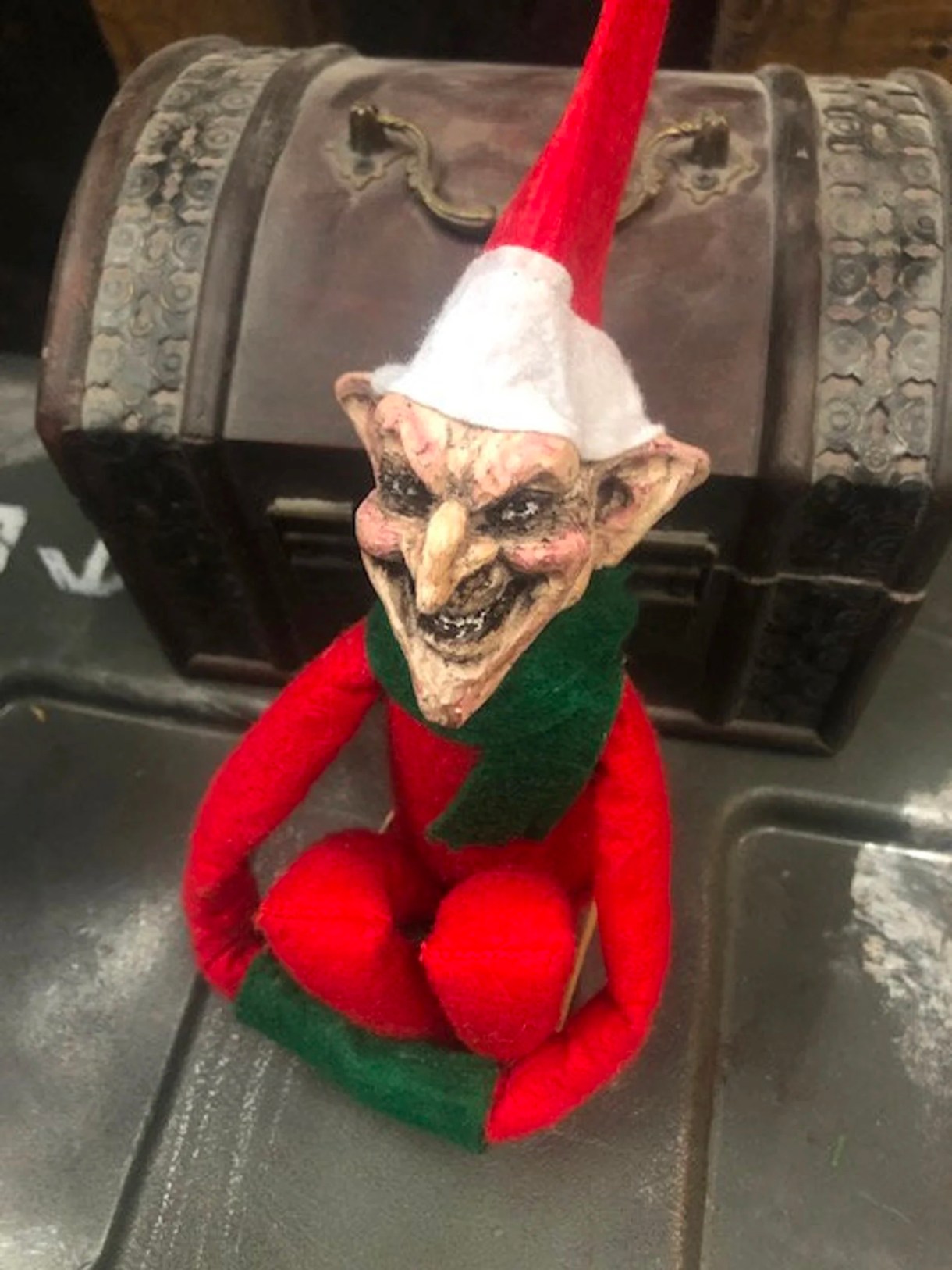 a creepy goblin version of the elf on the shelf, a long limbed Christmasy doll