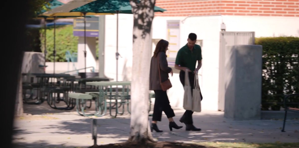 Hendrix handing tote bags to a woman she's walking with