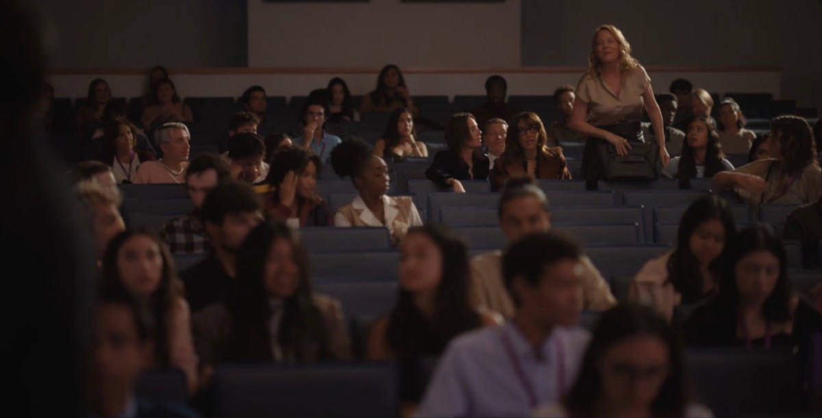 Tina standing up in the auditorium to yell