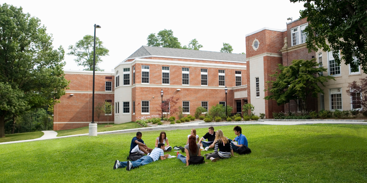 Students gathered on a lawn on a college campus