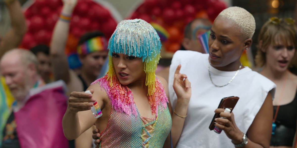 Two Black people at pride parade looking disgusted at a tiny bottle of booze. 