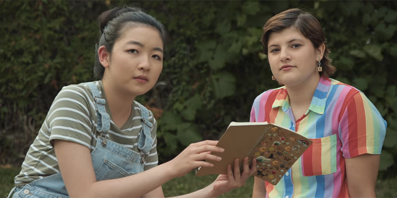Erin and Liz read a book on the lawn.