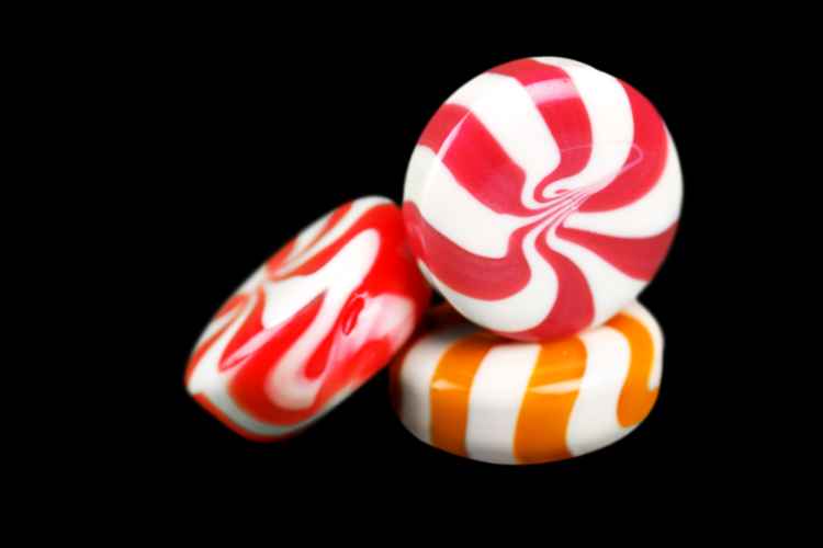 a stock image of some hard candy (the stripey minty kind) against a black background