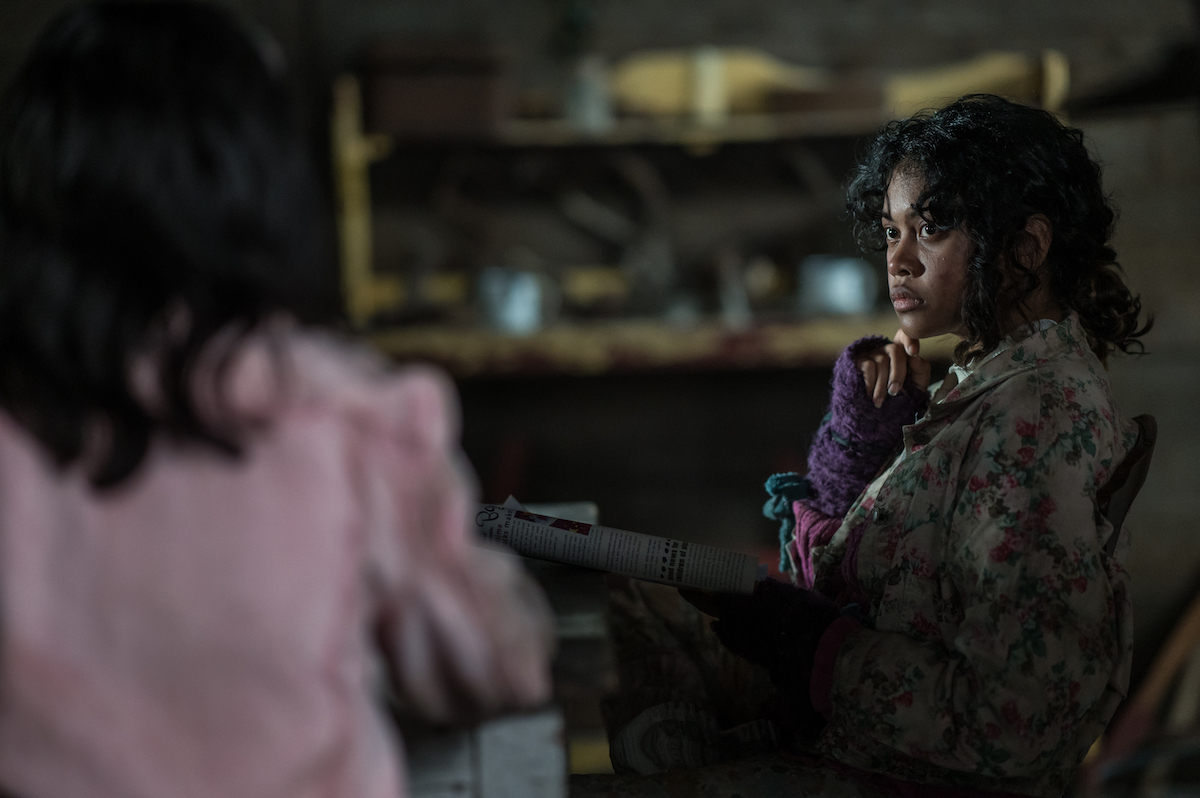 Nuha Jes Izman as Teen Crystal in YELLOWJACKETS Season 2 sits at a table. Photo Credit: Kailey Schwerman/SHOWTIME.