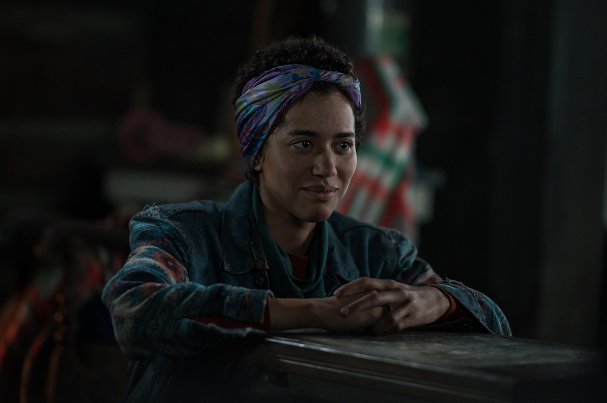 Yellowjackets Jasmin Savoy Brown as Teen Taissa in YELLOWJACKETS Season 2 sits and smiles. Photo Credit: Kailey Schwerman/SHOWTIME.